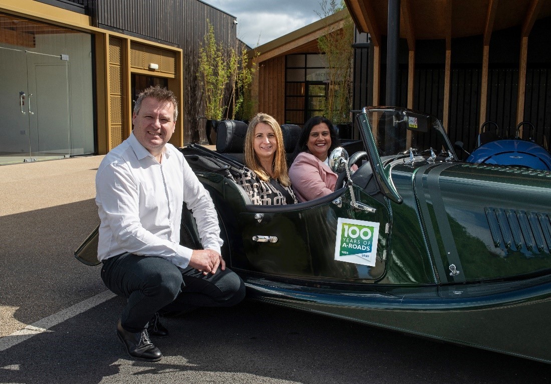 Image shows Chief Marketing Officer for Morgan Toby Blythe alongside Head of Planning and Development at National Highways Victoria Lazenby and Anita Prashar, Regional Director in the Midlands for National Highways who are both sitting in a Morgan car.