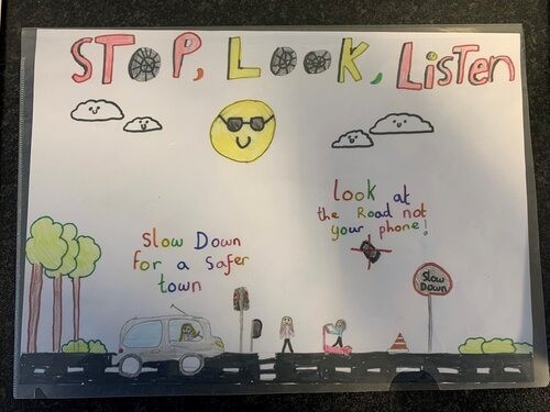 A poster created by one of the children saying 'Stop. Look. Listen' and depicting a road with cars on.